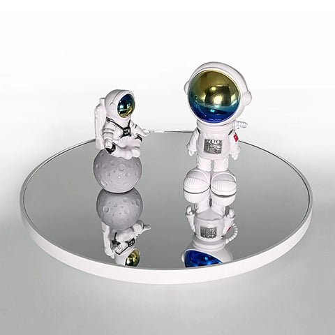 Ultimate 3 In 1 Motorized Rotating Display Stand With 360 Degree Electric Turntable And Swappable Covers For Professional Product Photography, Jewelry Shoots, Cake Presentations, And Live Videos In Sleek Black showcasing astronaut figurines on a reflective turntable.