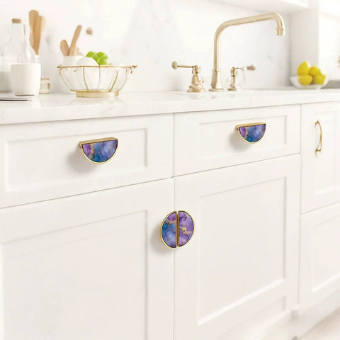 Two Pack Fluid Art Cabinet Pulls in Purple Teal Gold on white kitchen cabinets with gold semicircle design and marble-like pattern.