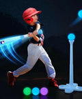 Child using Lit Light Up Tee Ball Set for Toddlers and Kids 3 to 8, hitting glowing ball with LED bat at night.