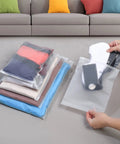 30 Pack Transparent Reusable Clothes Storage Bags With Zip Lock For Travel And Storage Grab And Go Durable Frosted Waterproof Organizers being used to pack clothes and accessories on a floor.