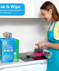 Woman using 100 Pack Microfiber Cleaning Cloths Dispenser Box Lint Free Ultra Absorbent Reusable Rags in kitchen for cleaning.