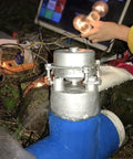 Close-up of 1000W 220V Water Turbine Generator for Remote Areas, blue 50mm pipe intake, outdoors with light bulbs for Off Grid Homes.