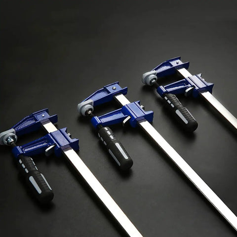 Professional Grade Eighteen Inch F Clamp Boasts A Smooth Quick Release Lever, four clamps lined up on a dark surface.