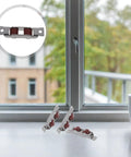 Wheeled Stainless Steel Sliding Window Rollers Feature Whisper Quiet Ball Bearing Action And Dead Smooth Gliding Motion Includes Four Heavy Duty Track Pulleys That Will Not Quit on window frame with red rollers and cup nearby.