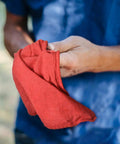 Person holding Heavy Duty Shop Towels 50 Pack Cotton Rags 14 By 14 Inches Lint Free Commercial Grade Red For Wet Or Dry Cleaning