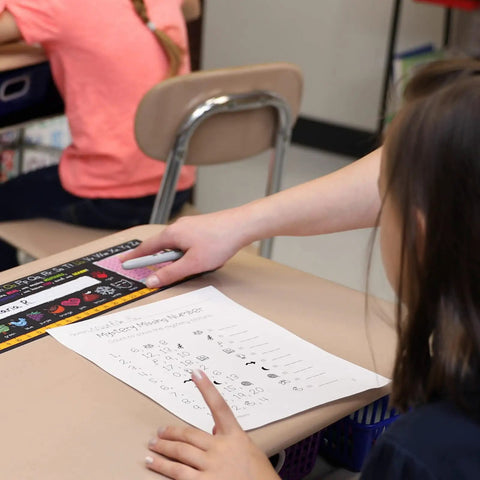 Top Shelf Chalkboard Style K-2 Desk Reference Mats, Built Tough Premium Plastic Teaching Companions For Elementary Students on a classroom desk.