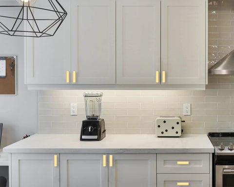 Modern kitchen with Ten Pack Brushed Gold Cabinet Knobs 2 Inch 50mm Single Hole Pulls installed on white cabinets and drawers ZH0026.