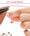 Close-up of a person holding a polymer clay mahjong bead with pliers, showcasing pre-drilled design for jewelry making.