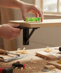 Hands using a Bubble Level Vial, Spirit Level to ensure a wooden shelf is level on a wall bracket.
