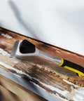 Two Point Five Inch Carbide Razor Blade Paint Remover Scraper on wooden surface, showing ergonomic handle and durable German tungsten blade.