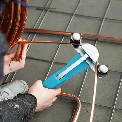 Person using the Duratech Heavy Duty Ratcheting Tube Bender Kit to bend copper tubing on a workshop floor.