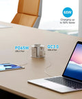 Slick Flush Mount Pop Up Socket Drops Straight Into Countertops Featuring Qi2 Magnetic Wireless Charger With 65W Fast Charging Double Usb Ports Zero Hassle Setup In Fresh White on a desk with tablet and laptop.