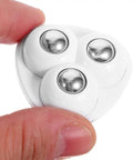Close-up of 12pcs Self Adhesive Furniture Casters ABS Steel 360 Degree with shiny round wheels held between two fingers.