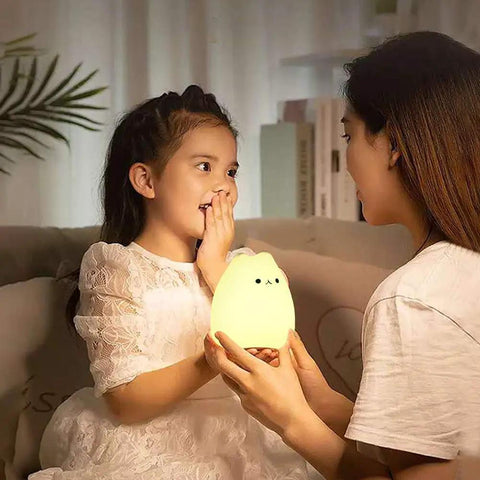 Child receiving LED Cat Night Light For Kids Battery Powered Silicone Cat Nursery Night Light With 2 Soft Glow Modes