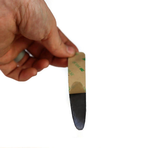 Hand holding a Calf Hair Recurve Bow Limb Dampener, showcasing peel-and-stick padding for quieter archery shots; 2 pack visible.
