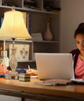 Cozy Farmhouse Table Lamp With Touch Control beside a woman working at a desk, showing linen shade and USB ports in use