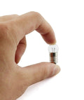 Heavy Duty E10 Miniature Screw Base Light Bulbs 1.5 Volt 0.3 Amp Pack Of Twenty Five held in hand, showcasing size and detail.