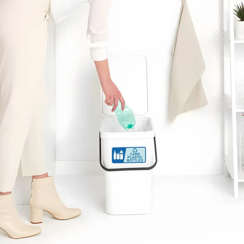 Person placing bottle in trash can with visible Two Pack Recycle Sign Stickers For Trash Cans, Waterproof Fade Resistant Vinyl Labels