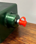 LockNLube red grease fitting cap installed on a metal grease fitting; side view