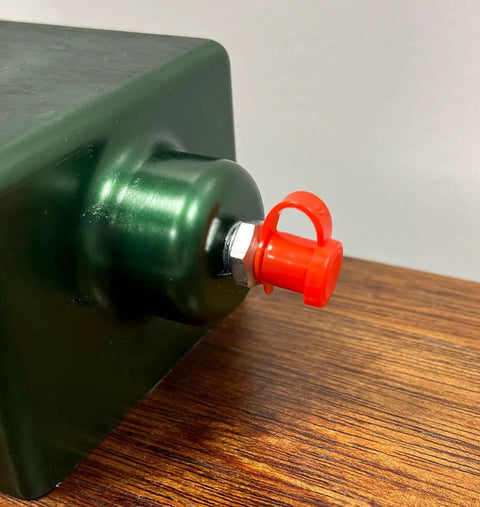LockNLube red grease fitting cap installed on a metal grease fitting; side view