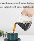 Top Shelf Cold Brew Coffee Maker With Clear Glass Carafe pouring coffee into a teal cup, showcasing its V-shaped spout.