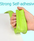 Hand holding green 78.7 Inch L Shaped Corner Protector Self Adhesive Foam Edge Guards For Sharp Furniture Corners Impact Absorption Kid Proof.