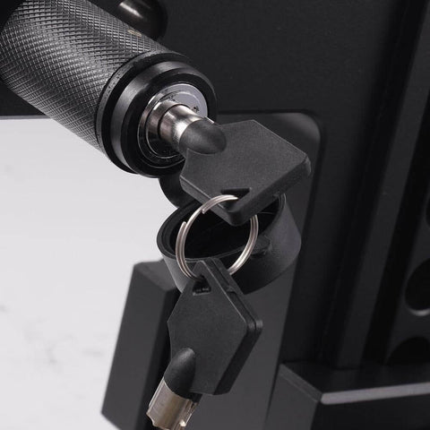 Close-up of a locking mechanism with keys inserted, part of a Five Eighth Inch Trailer Hitch Lock With Extra Long Four And A Half Inch Span For Three Inch Receivers Plus Two And A Half Inch And Two Inch Adapters Anti Rattle O Rings Locking Hitch Pin To Keep Your Trailer Truck Or Car Safe, showing textured grip and metal finish.