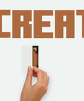 Hand applying Minecraft Eat Sleep Mine Create Peel And Stick Wall Decal Set on smooth surface, showing partial design.