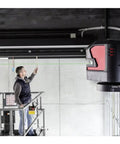 Knockout Green Beam Cross Line Laser Level projecting green lines as a user aligns fixtures on a scaffolding.