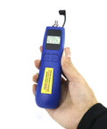 Hand holding blue Optical Power Meter With Universal 2.5mm Interface And Wide Range From Minus 70 To Plus 10 dBm For Fiber Optic Testing, display on