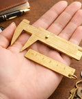 Hand holding brass mini 80mm double scale caliper handy portable sliding gauge for gemstones and jewelry making with 60mm brass ruler