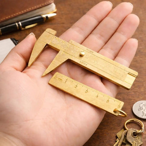 Hand holding brass mini 80mm double scale caliper handy portable sliding gauge for gemstones and jewelry making with 60mm brass ruler