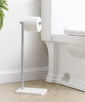 Natural Marble Toilet Paper Holder Stand Freestanding Stainless Steel with Brushed Finish next to a toilet in bathroom.