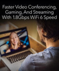Man using laptop with Nighthawk WiFi 6 USB 3.0 Adapter A7500 AX1800 for faster video conferencing and streaming.