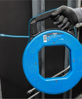 Person holding Sturdy 100 ft Stainless Steel Fish Tape With Metal Eyelet Tuff Grip Pro Case, showing nylon jacketed pulling tool.