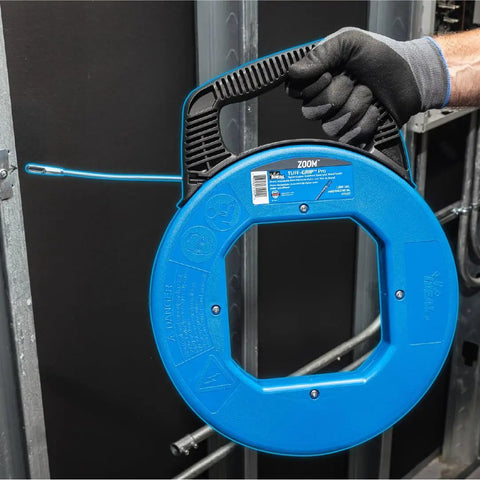 Person holding Sturdy 100 ft Stainless Steel Fish Tape With Metal Eyelet Tuff Grip Pro Case, showing nylon jacketed pulling tool.