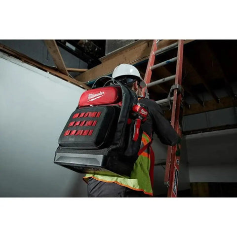 Heavy Duty Canvas Jobsite Backpack With 48 Pockets And Ultra Comfortable Load Bearing Harness Built Like A Tank For Real Deal Contractors And Crew Chiefs Who Want Solid Boss Gear On The Road, worn by a worker climbing a ladder.