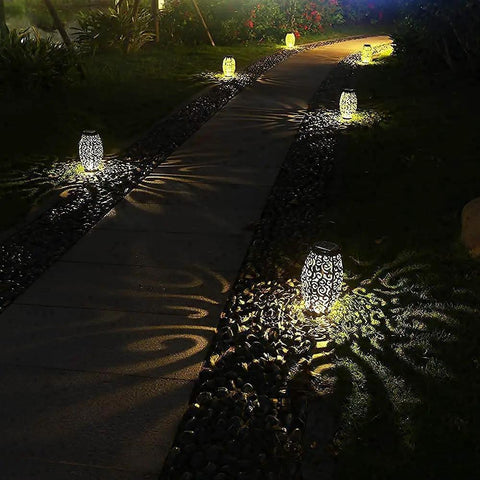 Solar Lantern Outdoor Hanging Light For Patio And Garden In Retro Metal Bronze Finish Waterproof Solar Garden Accent For Pathway And Yard Decor Easy Mount And Cozy Vibe Mother's Day Gift illuminating a garden pathway.