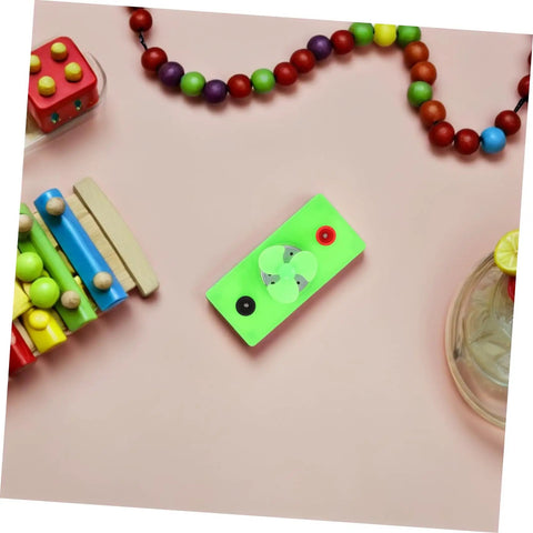 Green Solar Powered DC Motor DIY Kit Wind Turbine Generator For Science Projects on pink background, surrounded by beads.