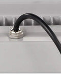 Close-up of black cable connection on back of aluminum 100W LED floodlight with heat dissipation features.