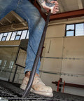 Worker using Round Three Quarter Inch Thirty Inch Connecting Bar With Fifteen Degree Angled Chisel End For Easy Alignment Prying And Chiseling Made In USA Sleever Bar on metal grating.
