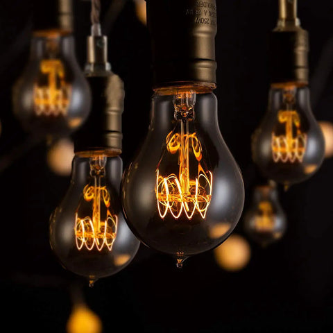 Edison Style Amber Filament Light Bulbs 40W A19 E26 Dimmable Antique Vintage Look Cozy Warm Glow 2700K in a dimly lit room