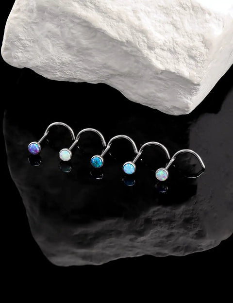 Five Pack 18g ASTM F136 Titanium Nose Studs With Vibrant Opal Tops For Nostril Piercings displayed against a dark surface.