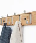 Slick Modern Wall Mounted Coat Rack In Brushed Brass With Heavy Duty Hooks For Entryway Living Room Or Kitchen To Hold Jackets Bags Hats And Umbrellas No Fuss Ever Durable Finish Looks Sharp While Sorting Daily Items Straight Up with towels hanging.