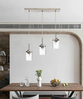 Black Island Pendant Lighting 5 Light Farmhouse Rectangle Linear Chandeliers With Clear Glass Shades hanging over dining table