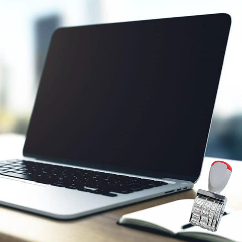 Slick Ergonomic Rubber Date Stamp With Comfortable Grip And Multifunctional Design For Scrapbooking And Office Documents next to a laptop on a desk.