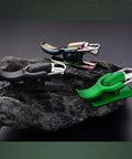 Three Cannon Surf Fishing Trigger Aids for Sea Casting in black, multicolor, and green on a rock display