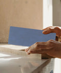 Hand using Silicon Carbide Sandpaper Sheets 36 Pack With Wet And Dry Sanding Pads Polishing Kit for smoothing wood surface.
