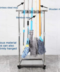 Movable Mop And Broom Holder Cart Rolling Cleaning Tool Rack Stainless Steel Stand holding various mops in a tiled room