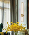 Slick Modern Wall Sconce Light Fixture Offering Three Color Temperatures And Built In Led Bulbs mounted beside a yellow flower arrangement.